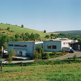 Fabrikgebäude mit grüner Landschaft im Hintergrund