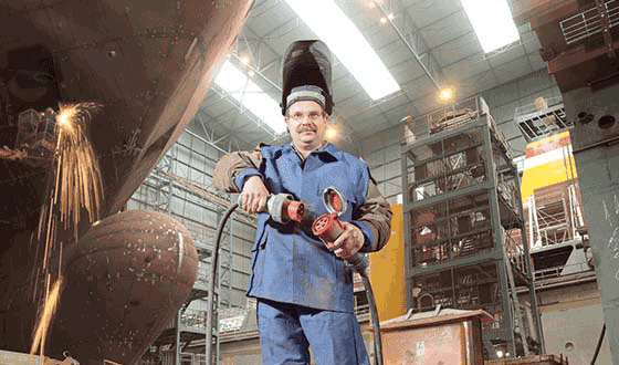 ein Bauarbeiter einer Werft in einem Blaumann steckt die MENNEKES Kupplung und Stecker zusammen