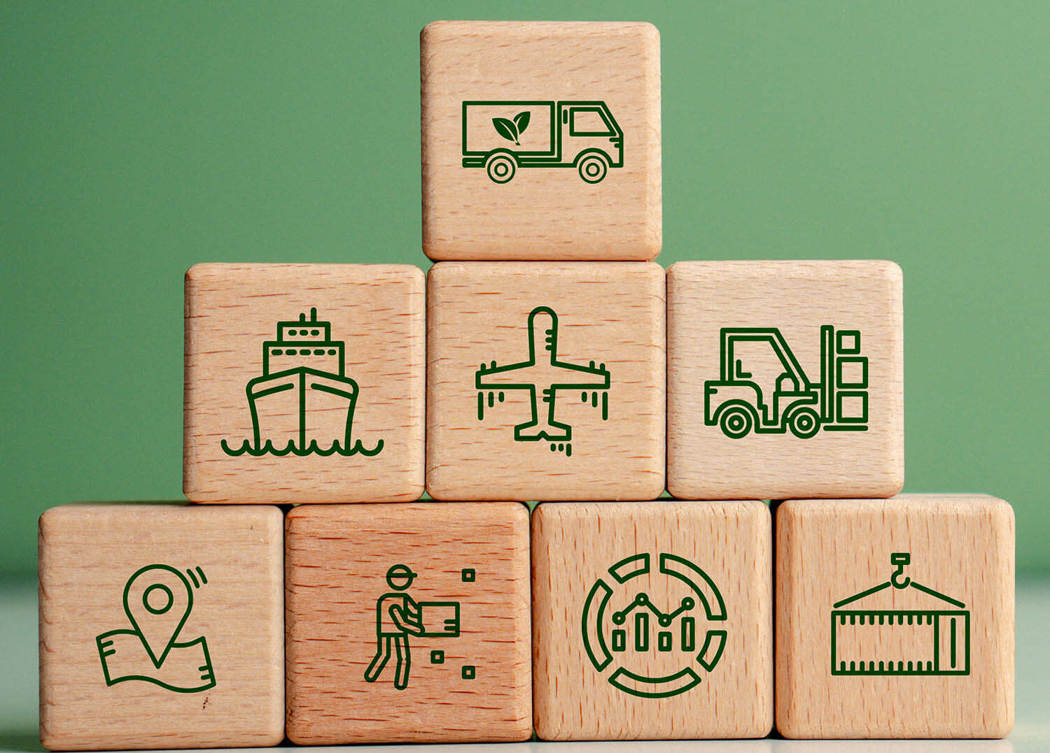 Lieferkettenmanagement Gestapelte Holzklötze mit grünen Icons für Transport, Logistik und Analyse auf grünem Fond.