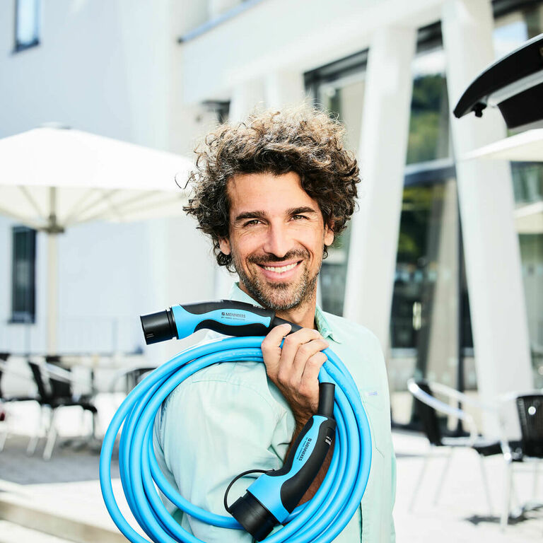 Mann mit MENNEKES Ladekabel Typ 2 Mode 3