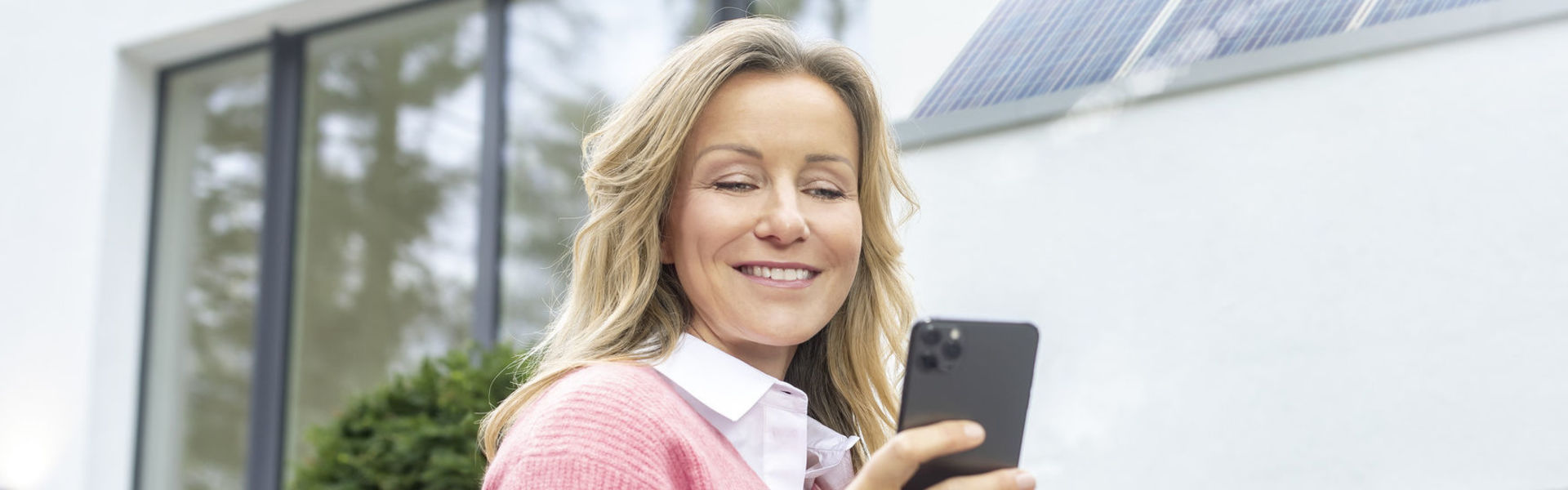 Frau nutzt den MENNEKES Wallbox Konfigurator auf ihrem Handy