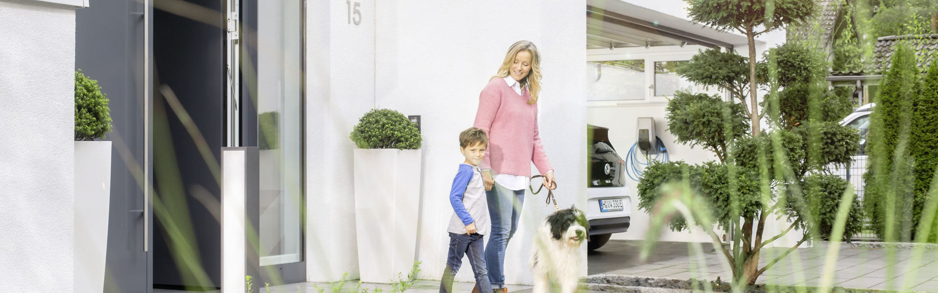 Familie mit Hund und MENNEKES Wallbox in Garage